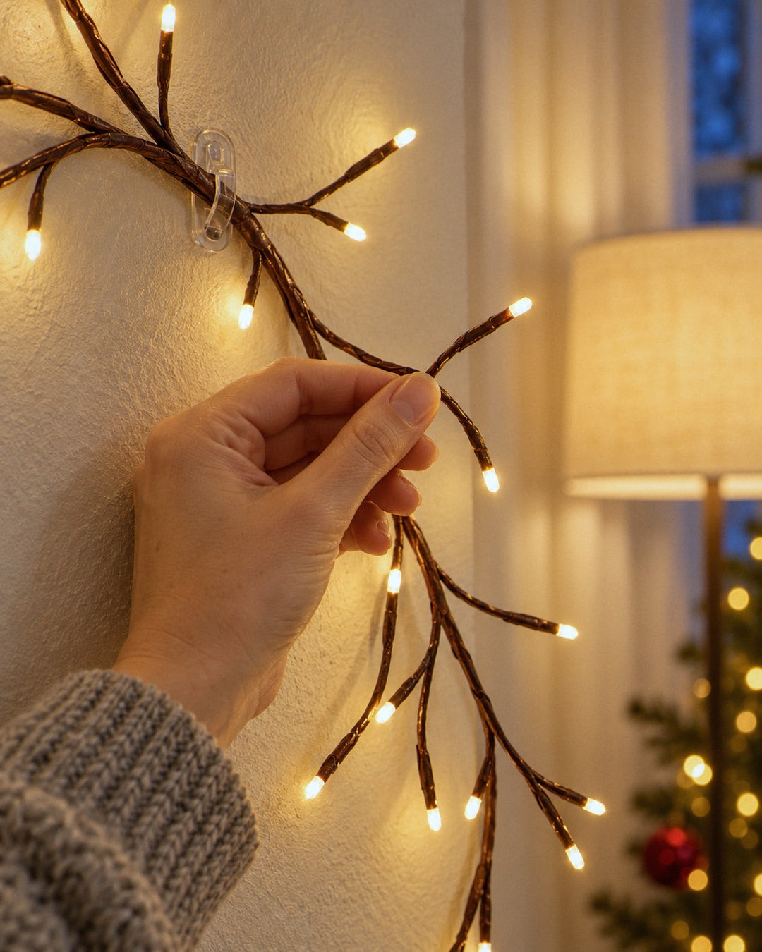 Lichter-Tannenbaum zum Biegen: dünne Drahtzweige mit kleinen LEDs in der Hand